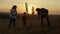 Family planting tree at sunset in countryside