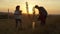 Family planting tree at sunset in countryside