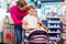 Family playing with baby doll carriage in toy store