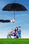 Family playing bubble at field under umbrella