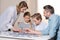 Family playing with puzzle on table at home together