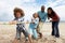 Family playing tug of war on beach