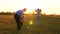 Family playing with younger baby with soccer ball in the park at sunset. Happy dad and child kick ball. happy family