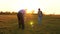 Family playing with younger baby with soccer ball in the park at sunset. Happy dad and child kick ball. happy family