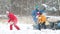 The family plays in the snow near a snowmobile in the winter forest