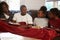 Family With Poor Diet Sitting On Sofa Eating Meal