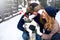 Family portrait of cute happy couple hugging with their alaskan malamute dog licking man`s face. Funny puppy wearing