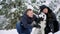 Family portrait of cute happy couple hugging with their alaskan malamute dog licking man`s face. Funny puppy wearing