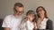 Family portrait - grandparents and grandchild having fun at home, together laughing. Grandfather sitting smiling while