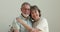 Family portrait happy loving aged couple embracing looking at camera