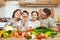 Family portrait in kitchen interior at home, fresh fruits and vegetables, healthy food concept, woman, man and children cooking an