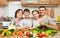 Family portrait in kitchen interior at home, fresh fruits and vegetables, healthy food concept, woman, man and children cooking an