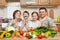 Family portrait in kitchen interior at home, fresh fruits and vegetables, healthy food concept, woman, man and children cooking an