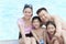 Family portrait, mother, father, daughter, and son, smiling by the pool