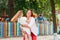 Family portrait. A mother lifts her daughter in her arms to spin the child around. Playground in the background.