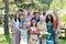 Family portrait at outdoor summer garden party. Family and friends standing, posing for a group photo. Multigenerational