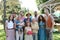 Family portrait at outdoor summer garden party. Family and friends standing, posing for a group photo. Multigenerational
