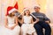 Family portrait - parent and children in home interior decorated with holiday lights and gifts, dressed in santa hat for new year