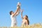 Family portrait. Picture of happy loving father, mother and their baby outdoors. Daddy, mom and child against summer blue sky.