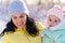 family portrait in the winter forest  mother and child  bright sunlight and shadows on the snow  beautiful nature