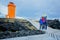 Family posing in front of lighthouse in lava field in beautiful nature in Snaefellsjokull National Park in Iceland