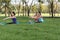 Family practicing yoga in the park outdoor. Concept of healthy l