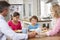 Family Praying Before Having Meal In Kitchen Together