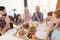 Family praying for a holiday table for Thanksgiving, holding folded hands in front of you