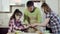 Family prepares meal and stretches round thick dough piece