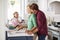 Family Preparing Roast Turkey Meal In Kitchen Together