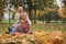 family pretend pyramid autumn park sitting between trees, smiling together.leaf fall, lifestyle.