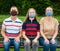 Family in protective face masks sitting on a bench  in the park