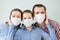 Family in protective medical masks. Mother, father, daughter protect themselves from the virus at home. Coronavirus