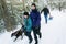 Family Pulling Sledge Through Snowy Landscape