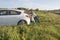 Family pushes the car in fields