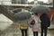 Family in the rain. People with umbrellas on the street. Walk around the city in rainy weather