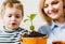 Family relationships. Mother with little son planting flower. Care for plants. Gardening discovering and teaching.