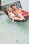 Family Relaxing In Beach Hammock