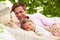 Family Relaxing In Beach Hammock With Sleeping Daughter