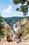 Family relaxing and enjoying beautiful view of waterfall on hiking trip in the mountains.