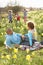 Family Relaxing In Field Of Spring Daffodils