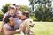 Family Relaxing In Garden With Pet Dog