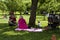 Family Relaxing on Grass in City Park