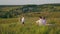 Family relaxing on hill and boy painting on easel