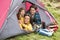 Family Relaxing Inside Tent On Camping Holiday