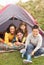 Family Relaxing Inside Tent On Camping Holiday