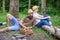 Family relaxing near bonfire after day of mushroom hunting. Family traditions. Couple relaxing after gathering mushrooms