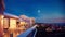 Family relaxing on roof top patio with evening city view