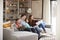 Family Relaxing On Sofa At Home Watching Television