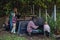 Family removing compost from a composter in garden, and composting kitchen waste in composter. Concept of composting and